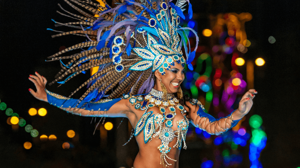 Image of a samba dancer in an extravagant costume adorned with feathers and sequins, smiling and dancing with visible joy during a night event.