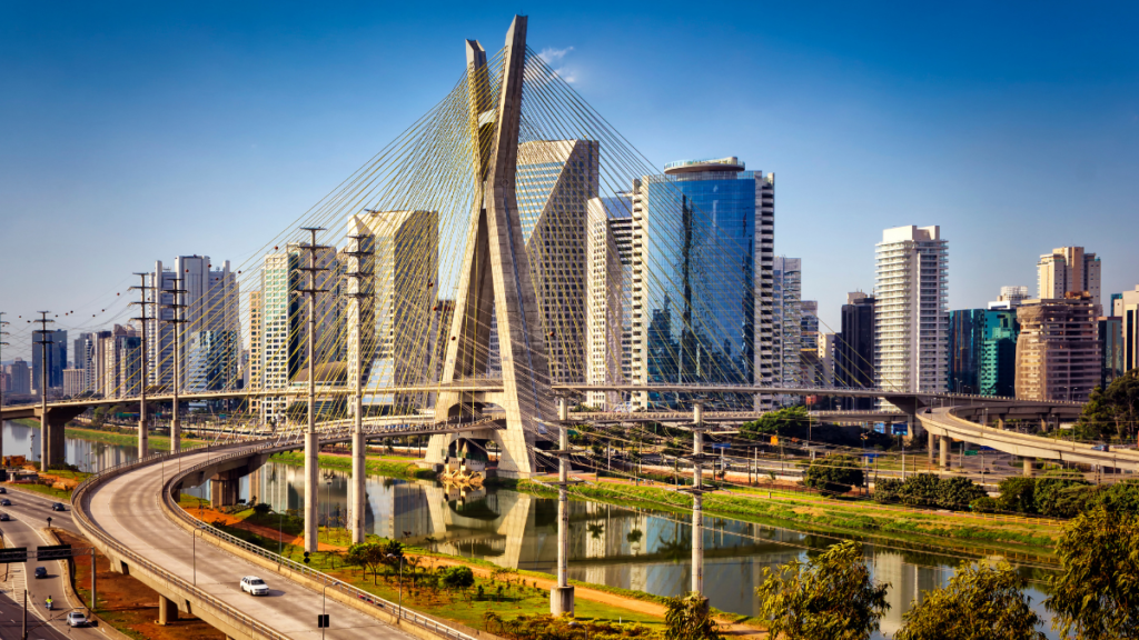 A panoramic view of São Paulo featuring the Octávio Frias de Oliveira Bridge, with modern high-rise buildings in the background.