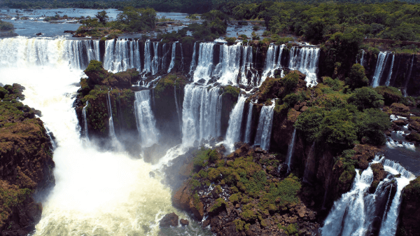 Aerial view of Iguazu Falls showcasing numerous cascades amid dense rainforest, illustrating the expansive scale of this natural wonder.