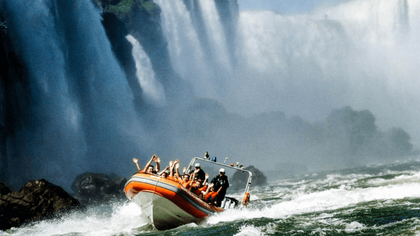 Thrill-seekers on a Macuco Safari boat ride at Iguazu Falls, braving the turbulent waters near the cascading falls