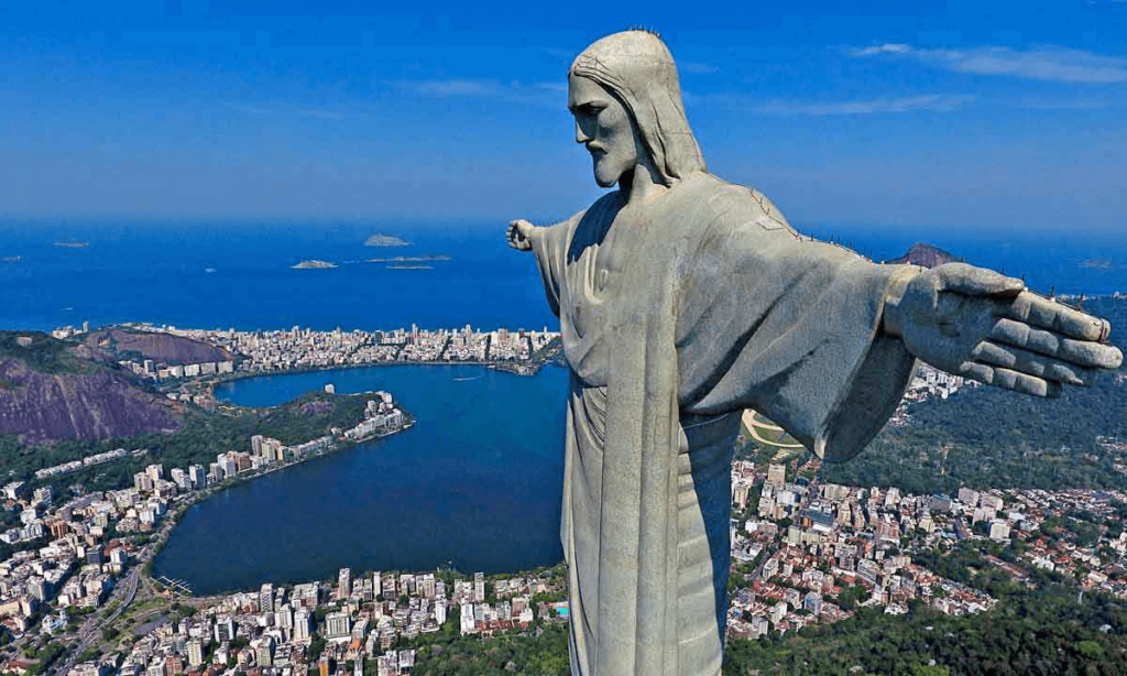 The iconic Christ the Redeemer statue in Rio de Janeiro, overlooking the cityscape from above, symbolizing the widespread Catholic faith in Brazil.