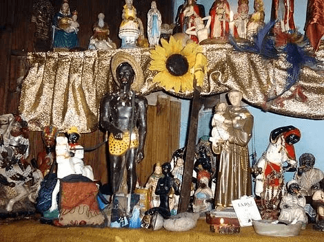An altar crowded with a mix of Catholic saints and African deities, illustrating the syncretism prevalent in Brazilian religious practices.